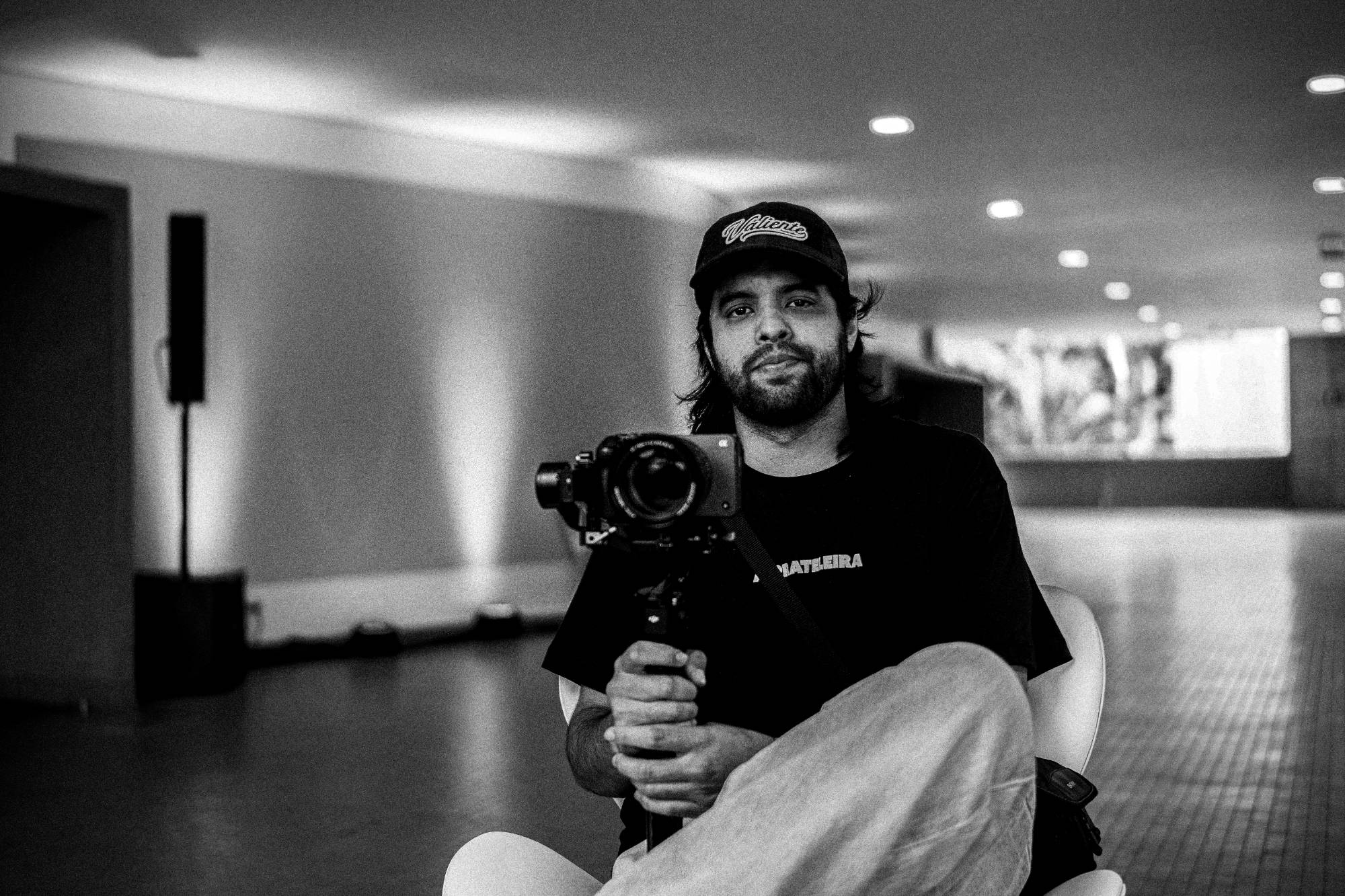 Victor Yokoy sentado, segurando uma câmera num gimbal